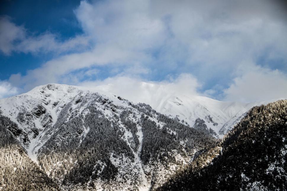 Free Image of Snow-covered mountain peaks under blue sky 