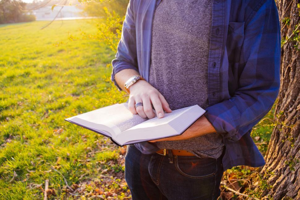 Free Image of Man reading in sunlit park on autumn day 