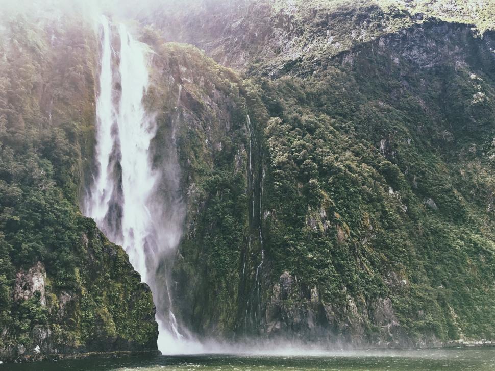 Free Image of Majestic waterfall in lush green setting 