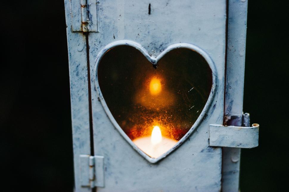 Free Image of Heart shaped window with glowing candle 
