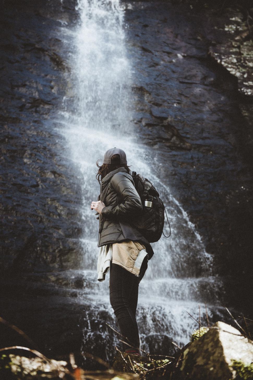 Free Image of Explorer in front of majestic waterfall 