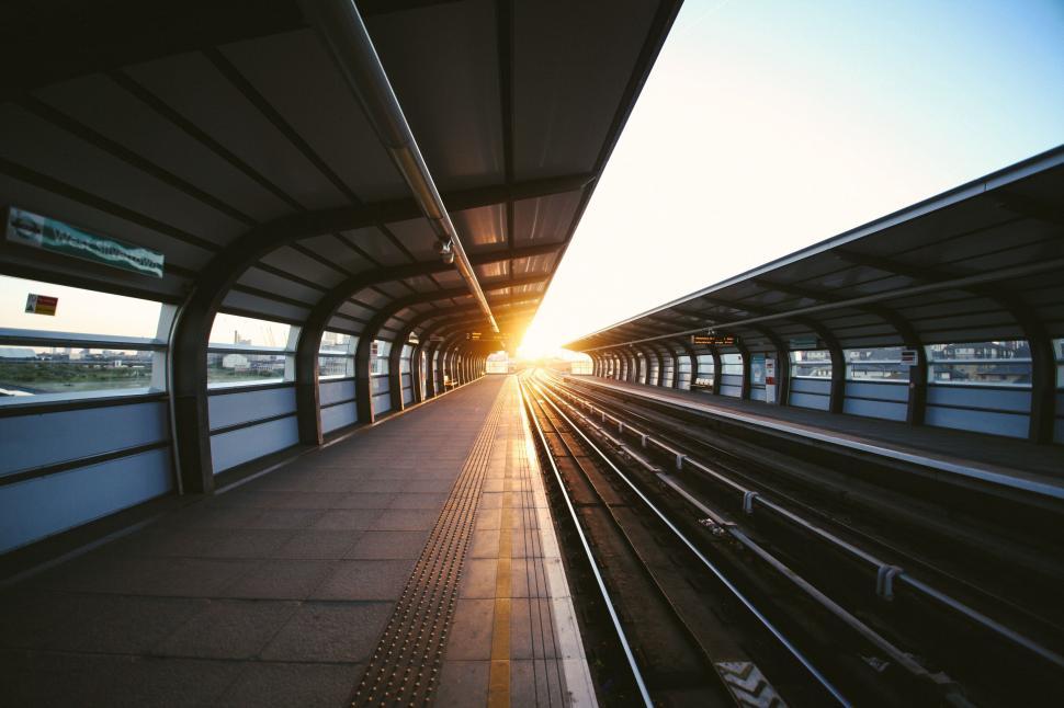 Free Image of Sunset glow over an empty train station platform 