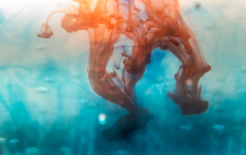 Free Image of Turquoise and orange ink swirling in water 