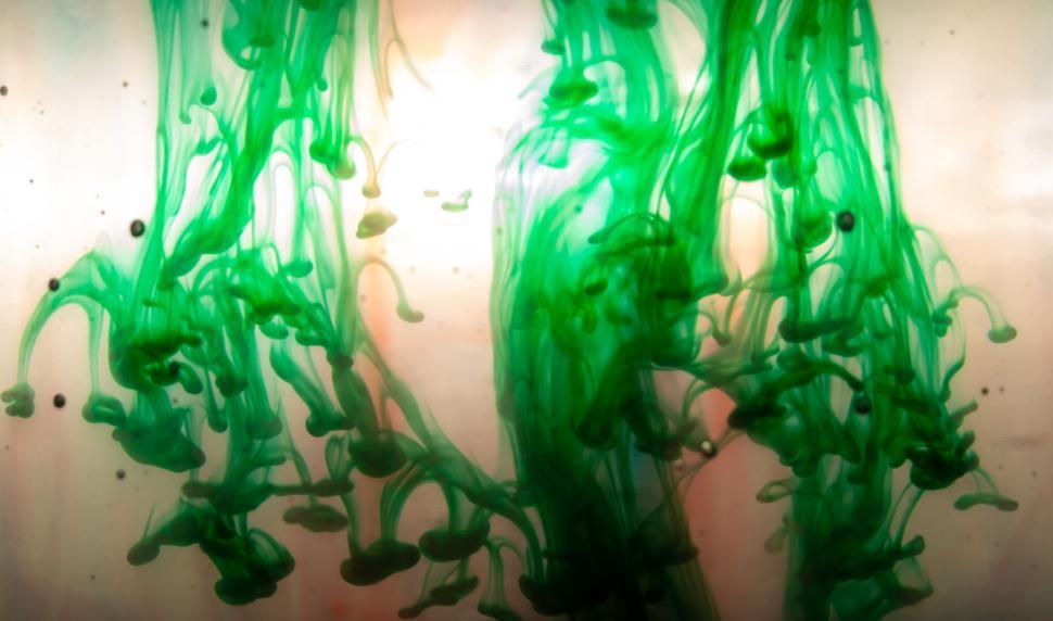 Free Image of Green ink swirling in water on soft background 