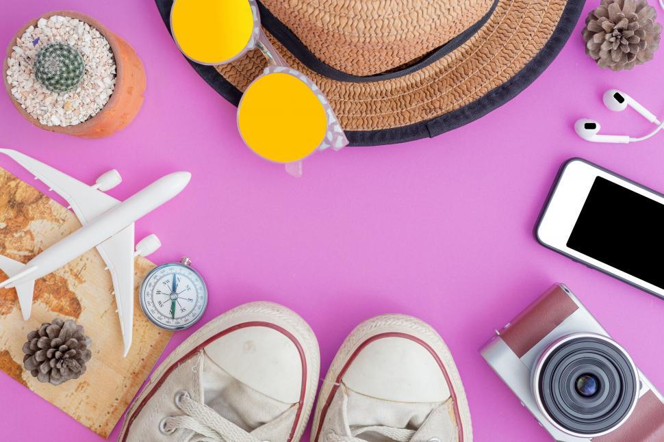 Free Image of Travel essentials and vacation items on pink 