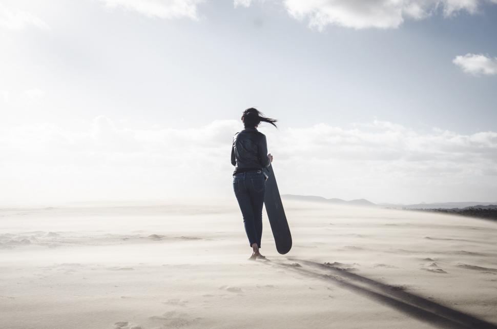 Free Image of Woman walking alone in vast desert landscape 