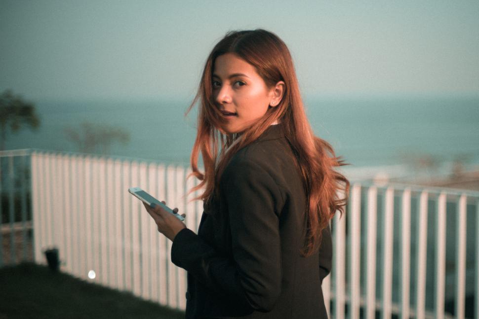 Free Image of Pensive woman with smartphone at twilight 