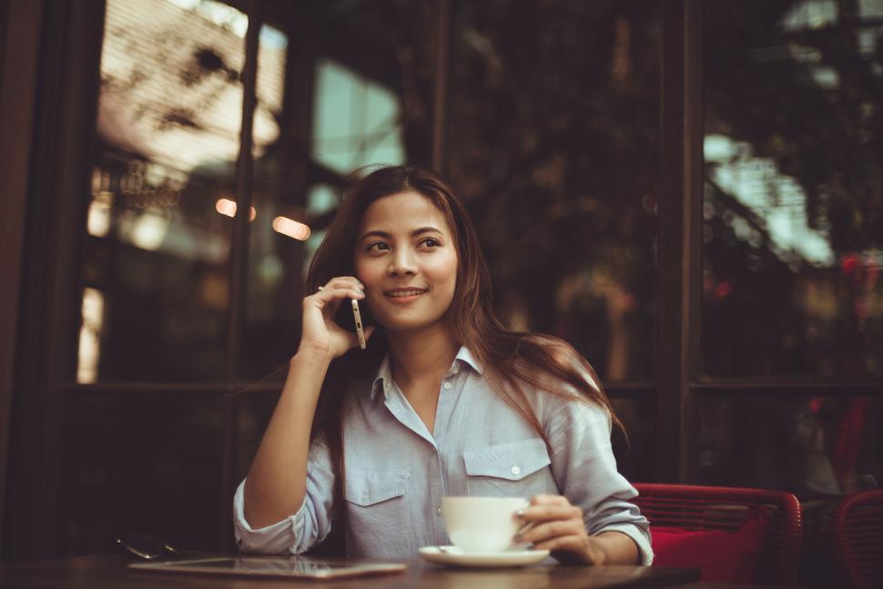 Free Image of Woman on phone in a cozy caf? setting 