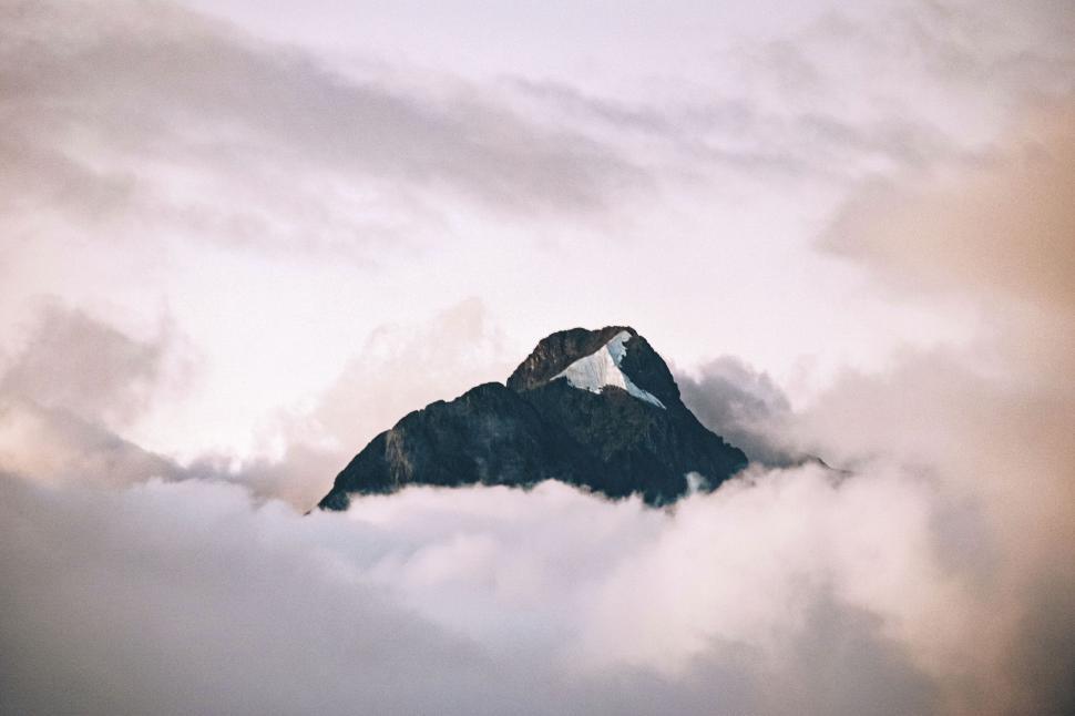 Free Image of Mountain peak emerging through clouds 