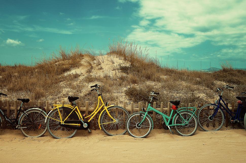 Free Image of Colorful bicycles parked on sandy beach 