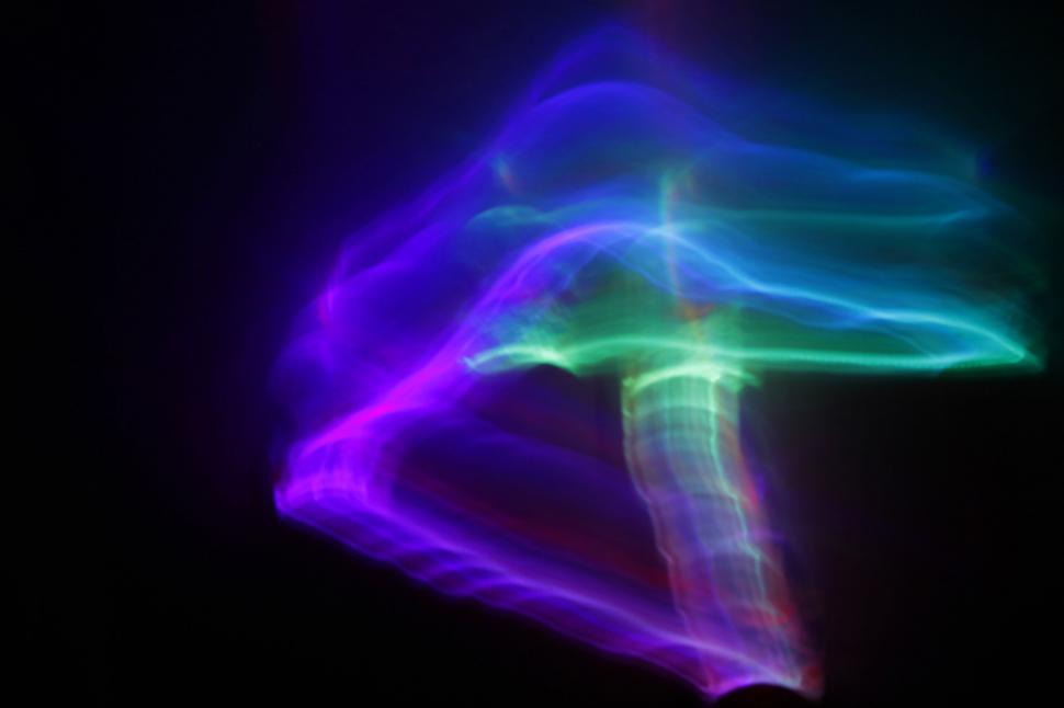 Free Image of Abstract colorful light trails on black background 