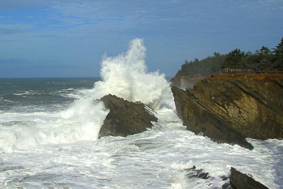 Free Image of Majestic waves crashing against rocky cliffs 