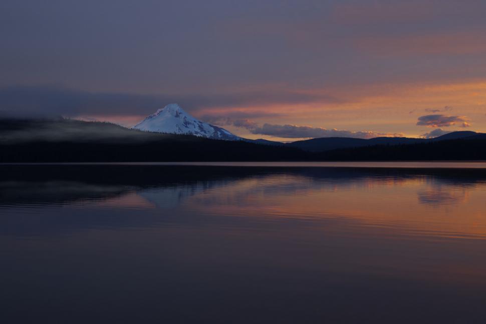 Free Image of Sunset over calm lake with mountain reflection 
