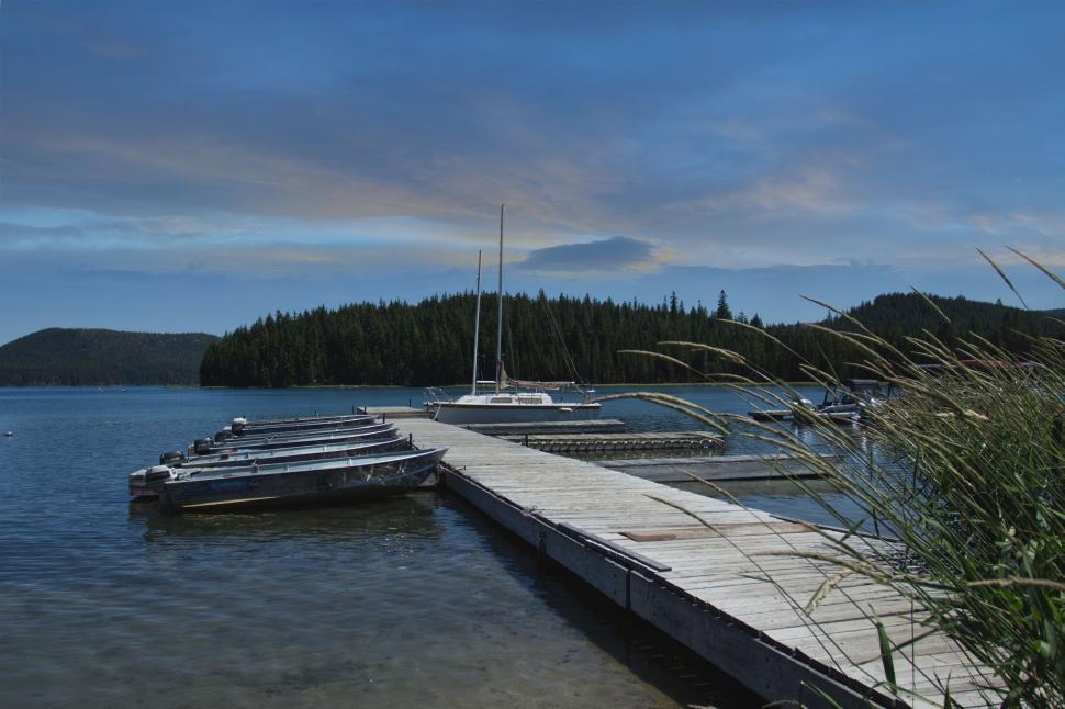 Free Image of Tranquil lakeside dock with sailing boats 