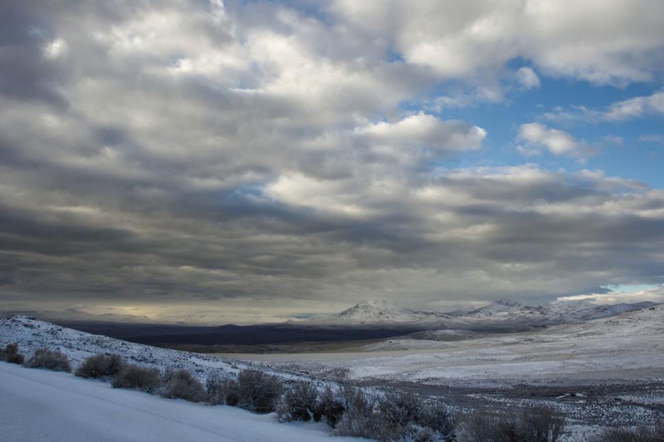 Free Image of Snowy landscape with dramatic clouds and mountains 
