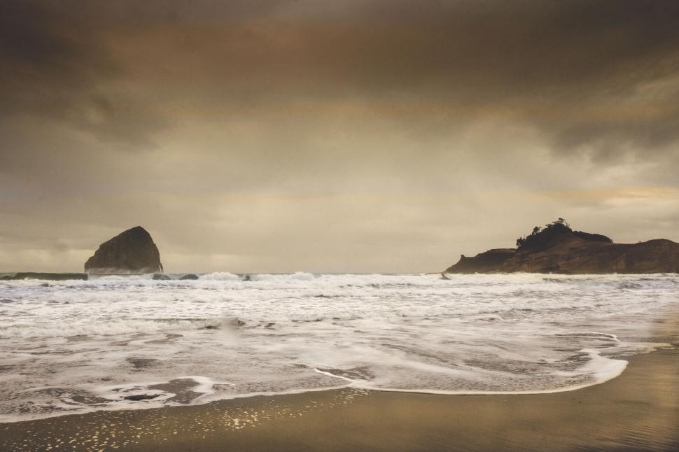 Free Image of Moody beach with dramatic rock formation 