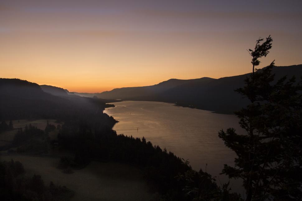 Free Image of Sunset over a tranquil river valley landscape 