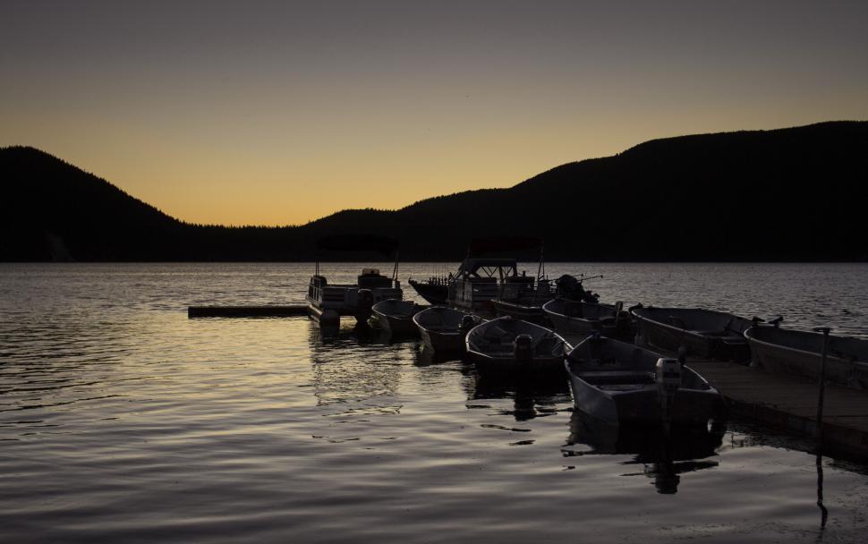 Free Image of Silhouetted boats at dusk on serene lake 