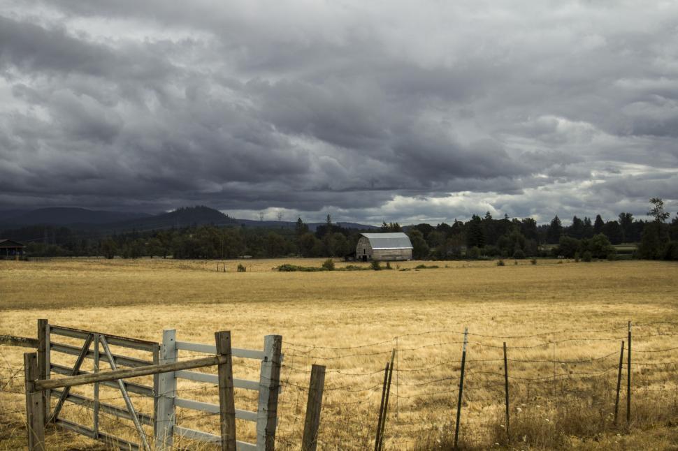 Free Image of Stormy clouds over rustic barn in field 