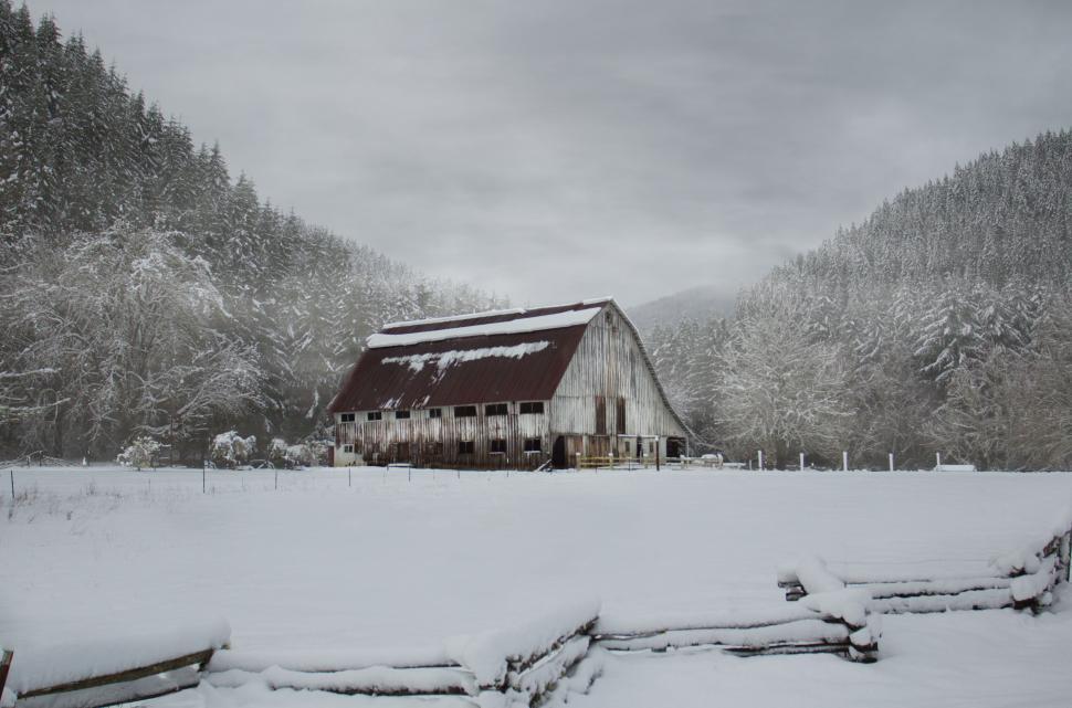 Free Image of Snow-covered old barn in mountain valley 