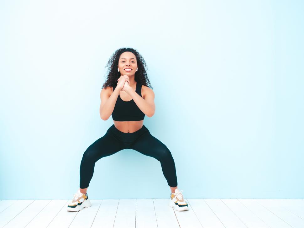 Free Image of A woman squatting with her hands together 