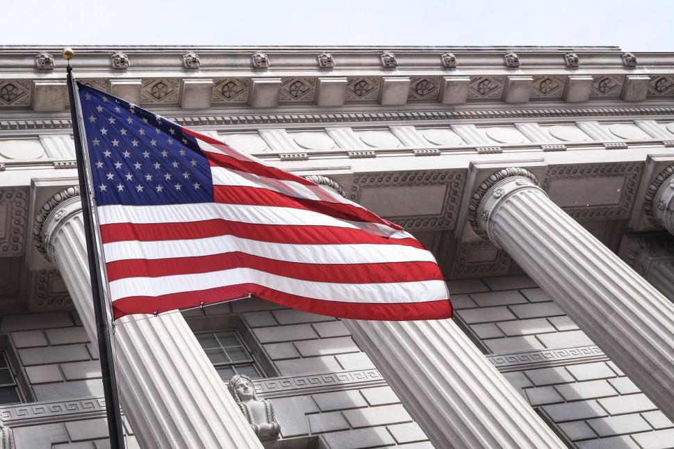 Free Image of American flag waving before a courthouse 