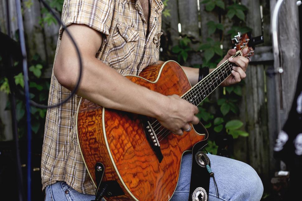 Free Image of Man playing an acoustic guitar in casual attire 