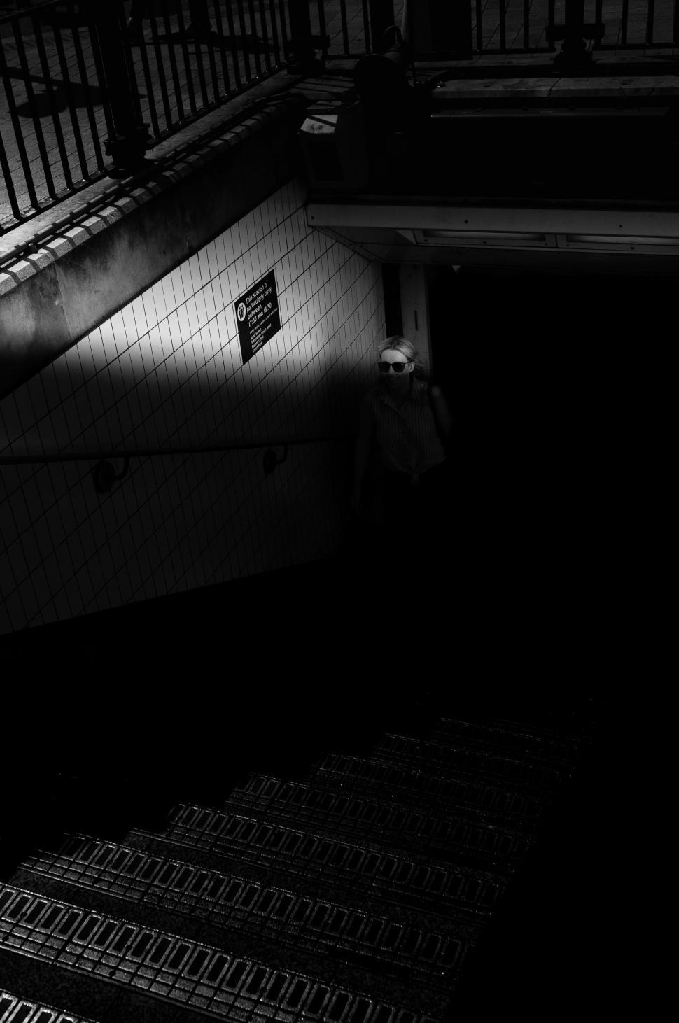 Free Image of Dimly lit station stairway with solitary figure 