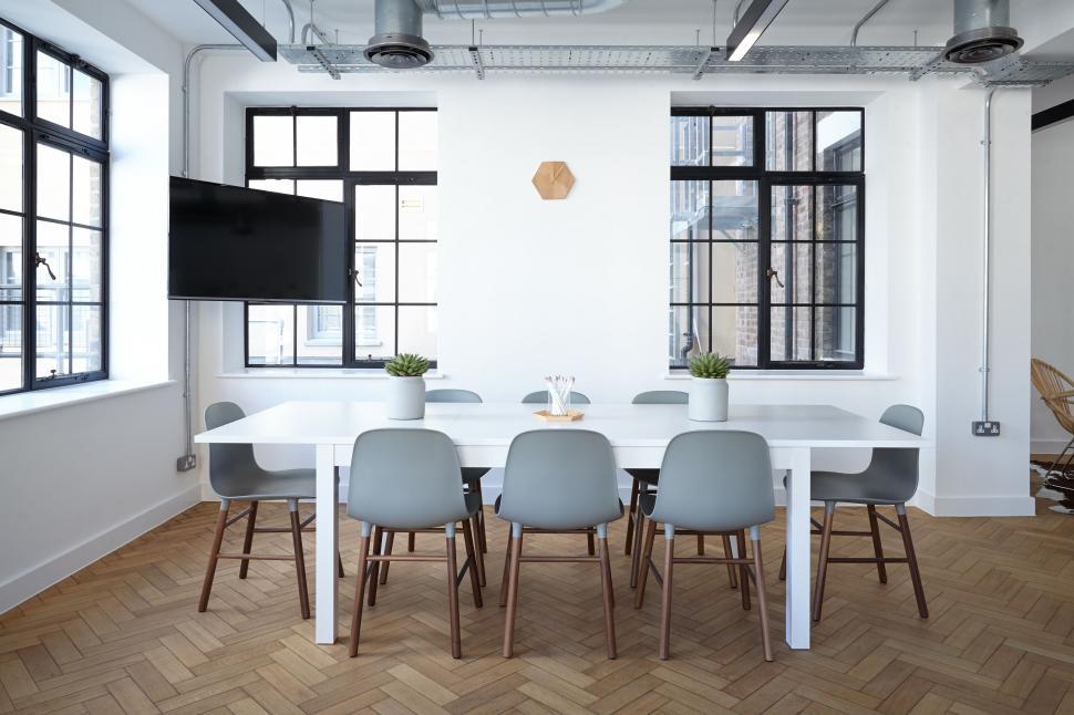 Free Image of Sleek meeting room with white furniture and TV 