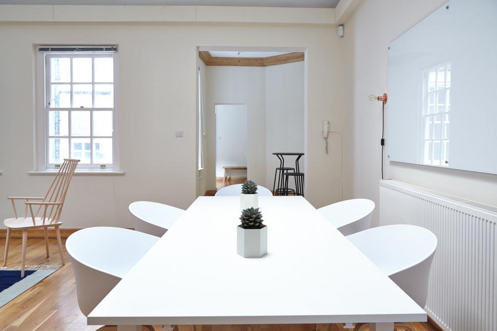Free Image of Minimalist white conference room with oval table 