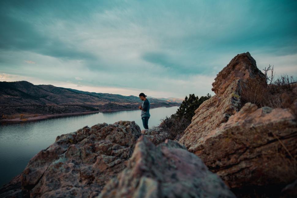 Free Image of Adventurous man overlooking a tranquil lake 