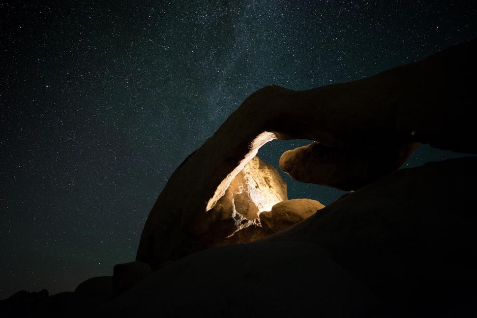 Free Image of Starry night over illuminated rock formation 