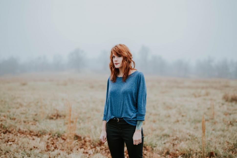 Free Image of Woman in blue sweater in misty field 