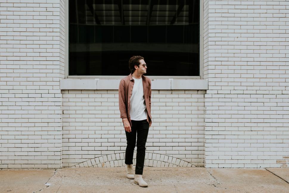 Free Image of Man in casual attire against brick wall 