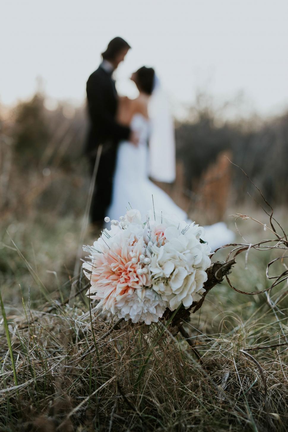 Free Image of Wedding couple with focus on the bouquet 