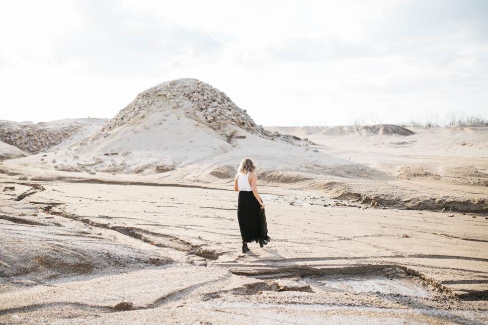 Free Image of Woman walking through a desolate landscape 