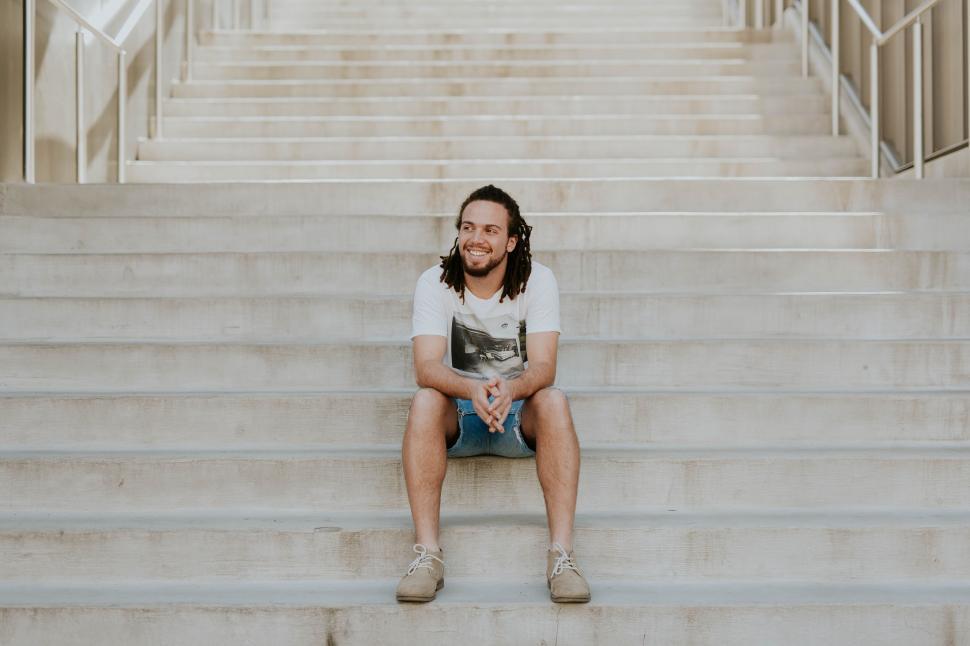 Free Image of Man sitting on steps smiling at camera 