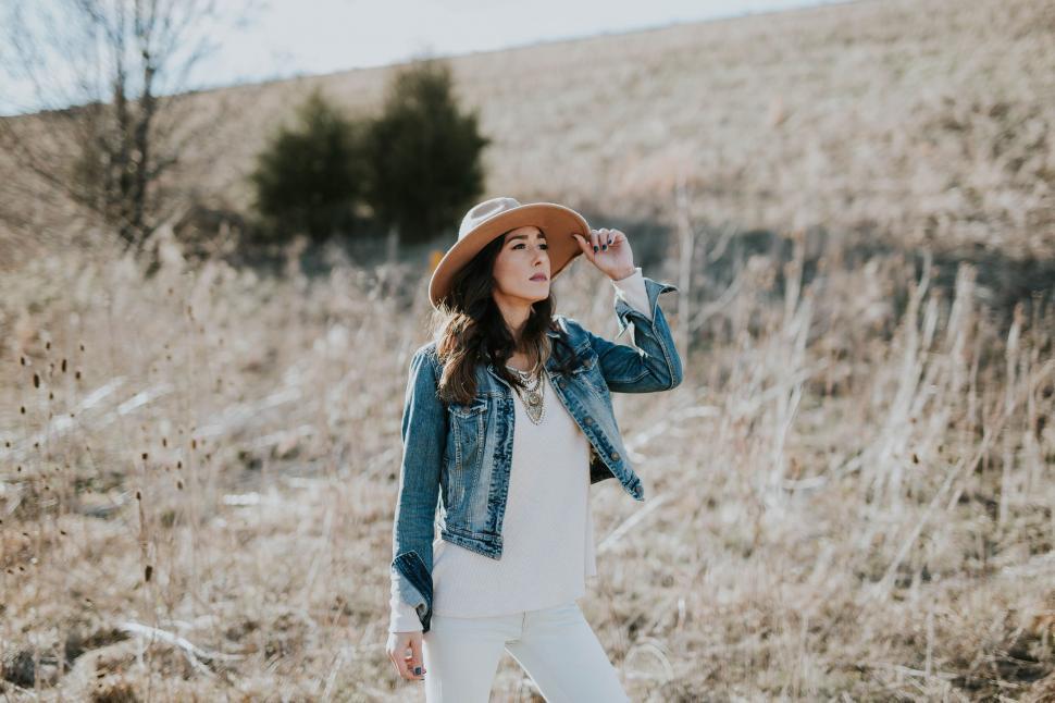 Free Image of Woman in field wearing hat and denim jacket 