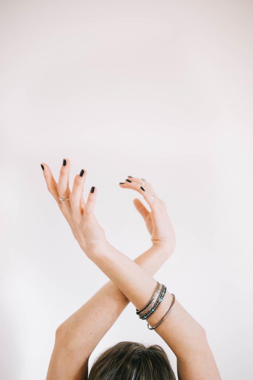 Free Image of Elegant hands raised in a soft backdrop 