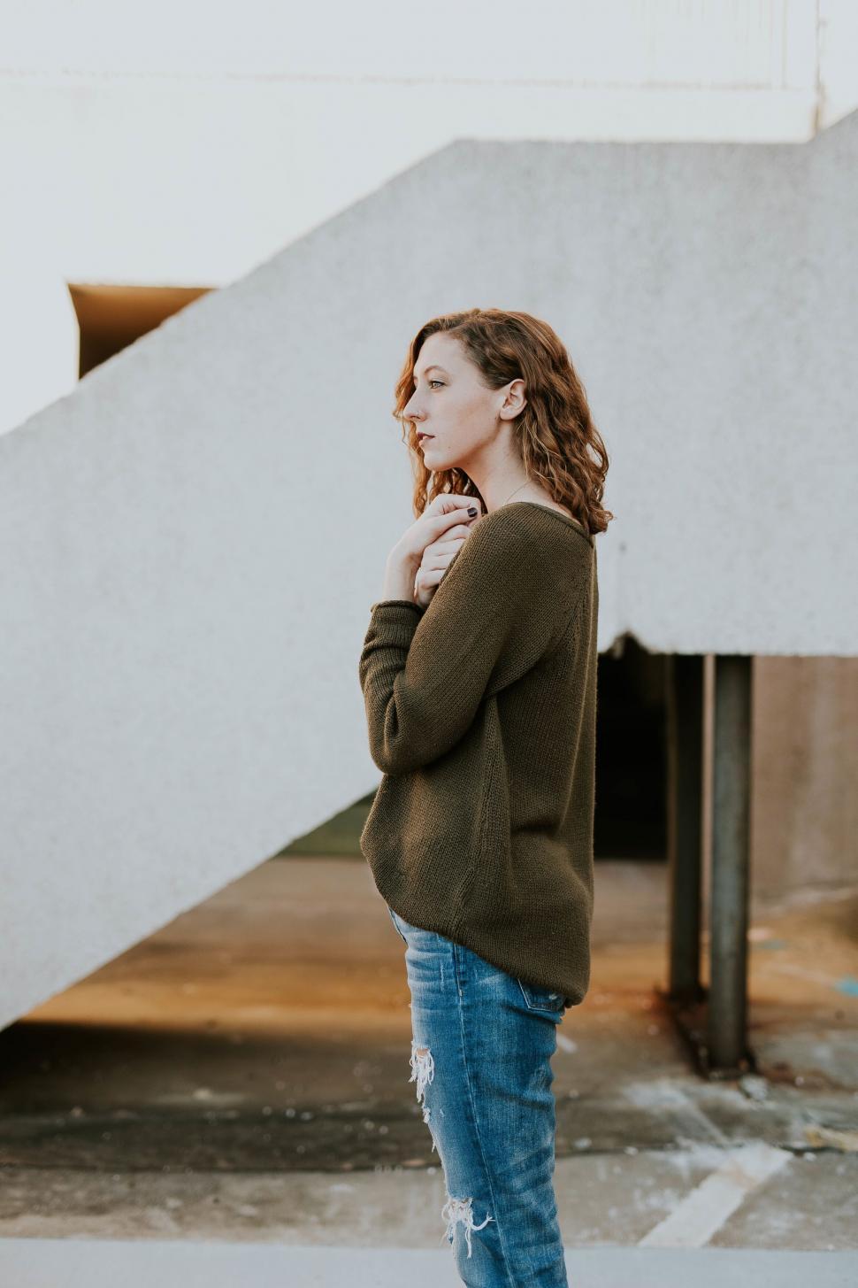 Free Image of Woman looking over shoulder in urban setting 