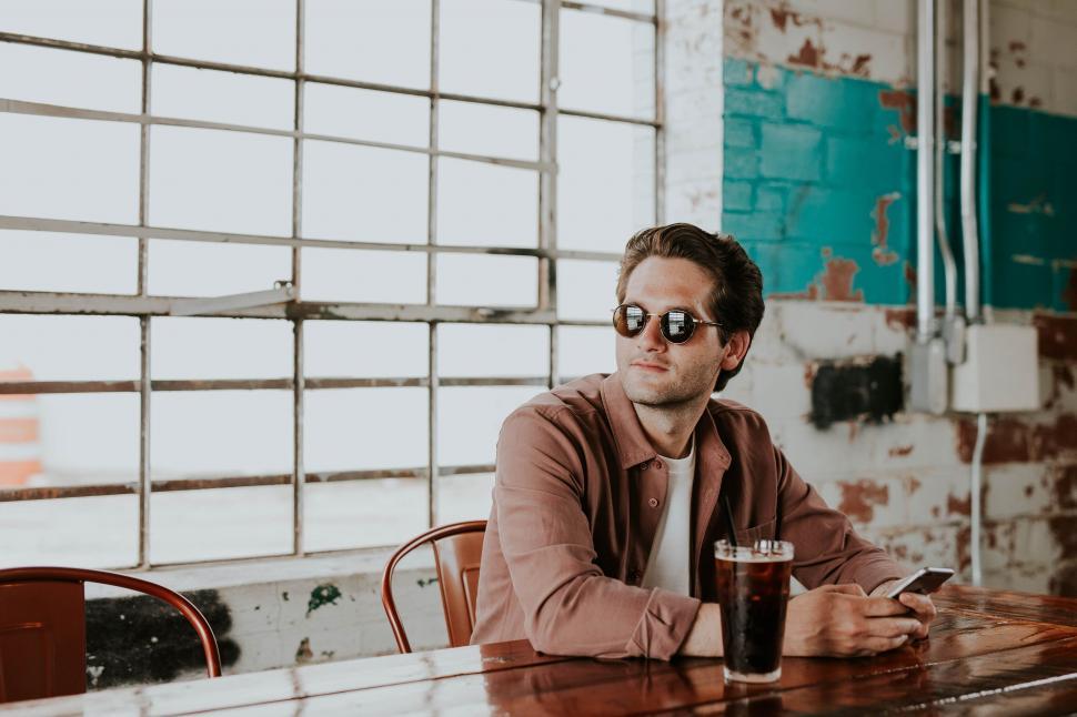 Free Image of Man with drink in industrial-style loft space 