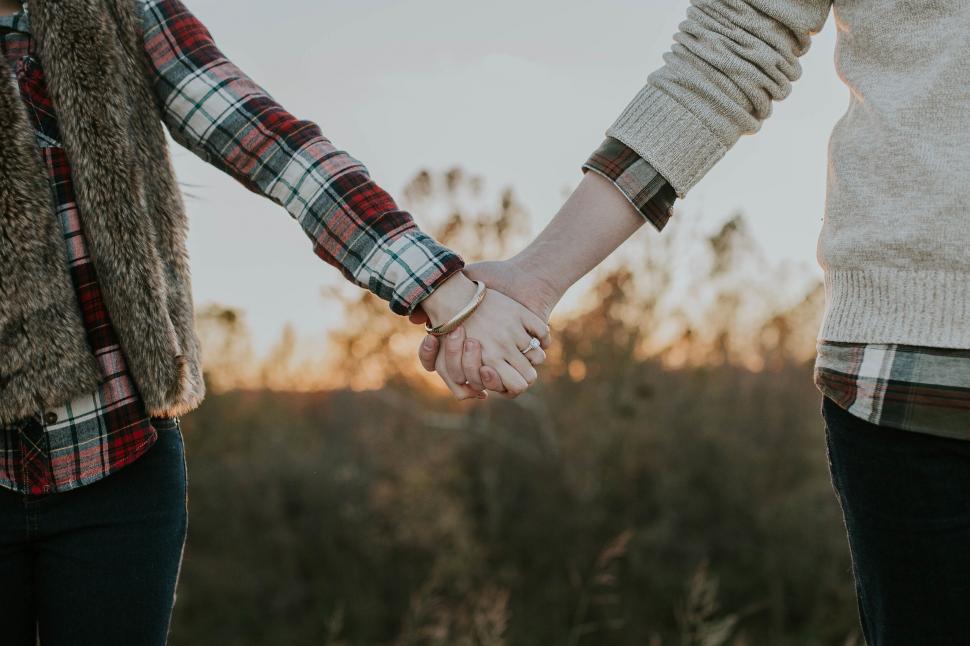 Free Image of Couple holding hands in a warm embrace 