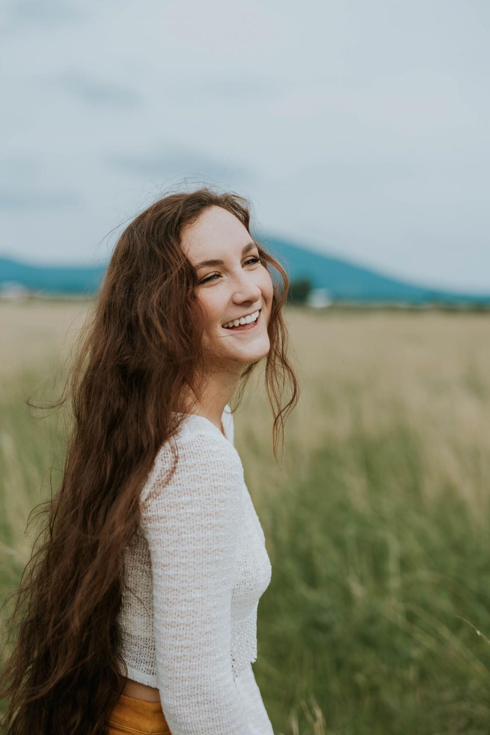 Free Image of Smiling woman with mountains in the distance 