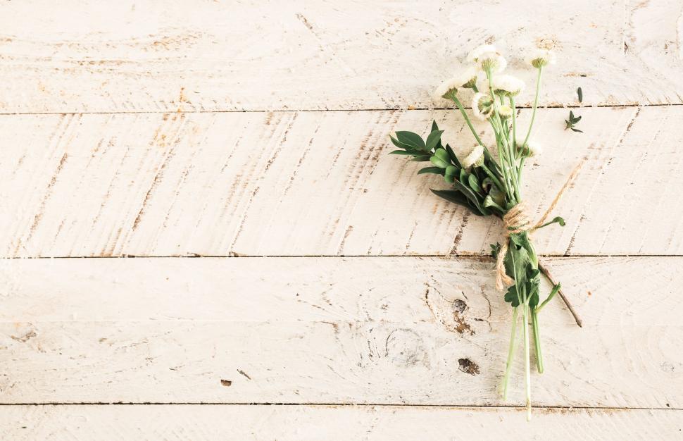 Free Image of Delicate flowers tied with twine on wood 
