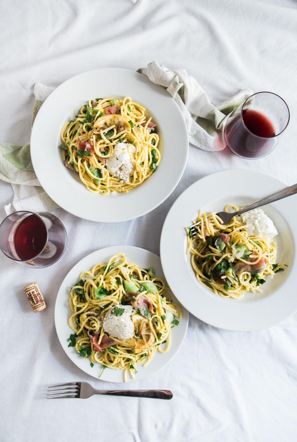 Free Image of Pasta dishes with wine on a bed setting 