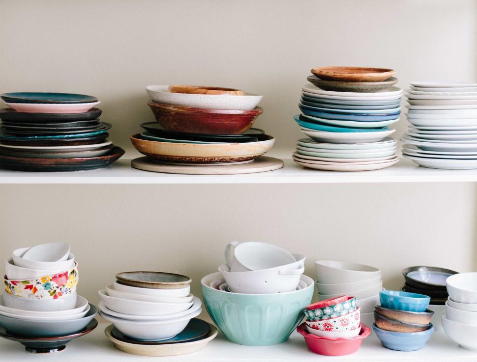 Free Image of Stack of assorted dinner plates on shelf 