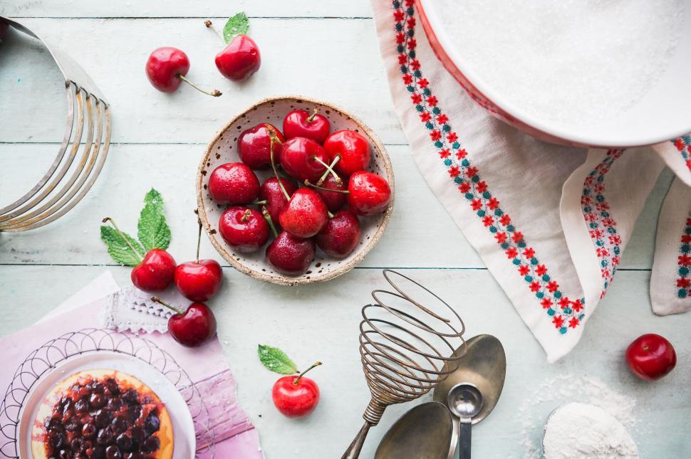Free Image of Table setup with fresh cherries and baking supplies 