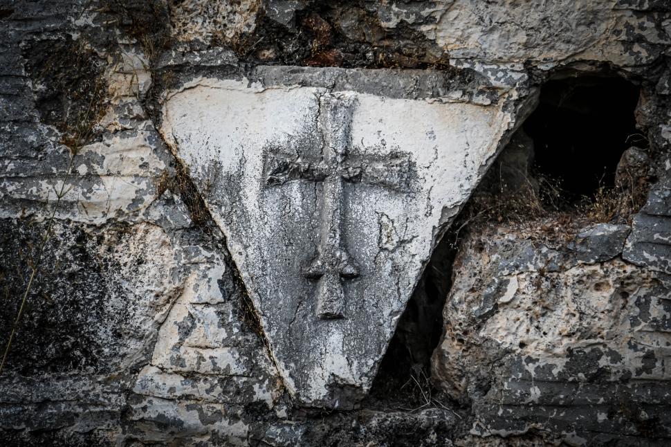Free Image of Ancient stone cross carved in rock wall 