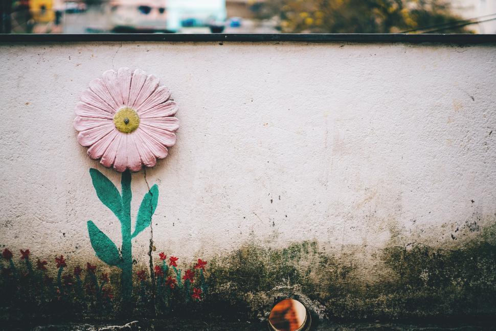 Free Image of Hand-painted flower on a weathered wall 
