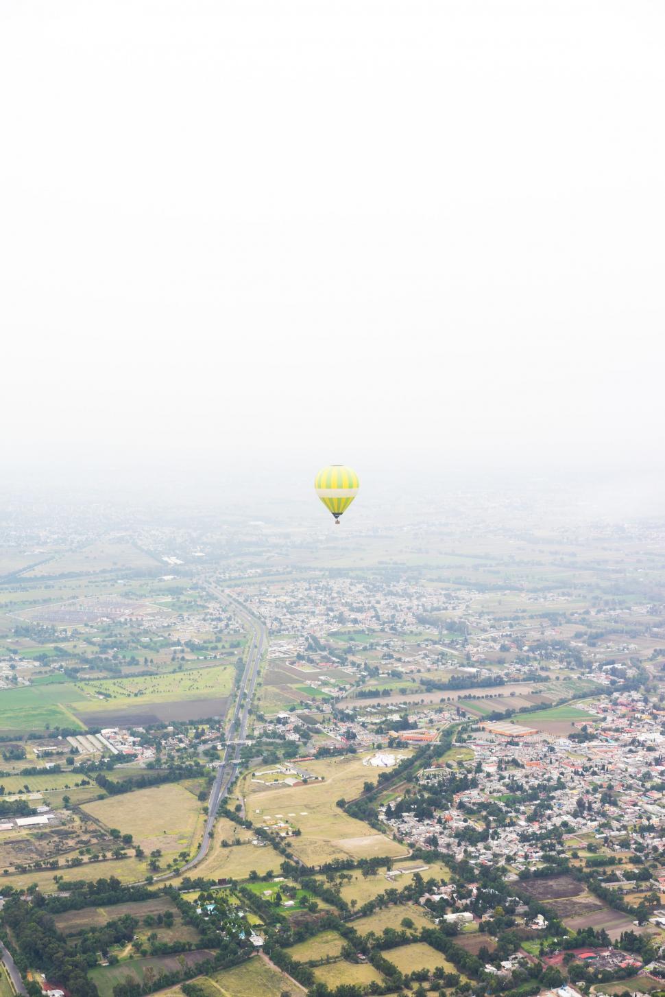 Free Image of Hot air balloon floating over rural landscape 